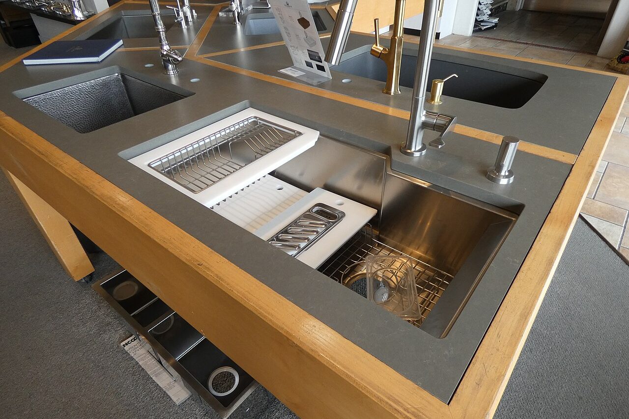 Large stainless steel commercial-grade sink with multiple basins and faucets